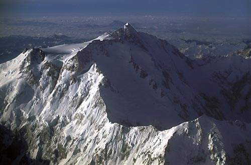 Το Nanga Parbat από αεροπλάνο. Η κόψη που κυριαρχεί είναι η Chongra και έχει βόρεια κατεύθυνση. Η διαδρομή του Buhl ακολούθησε τον ορίζοντα από την αριστερή πλευρά της φωτογραφίας (κόψη Rhakiot). Στο τέλος της ανάβασής της προς το μεγάλο πλατό, διακρίνεται η βραχώδης έξαρση της "Ασημένιας Σέλλας". Στη σκιασμένη βόρεια πλευρά του βουνού, υπάρχουν οι παγετώνες Rhakiot και Diamirai